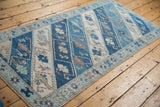 Distressed Oushak runner detail: starburst border, barber poled vinery on indigo and ivory.