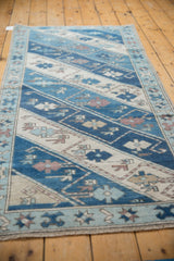 Vintage Oushak rug side border with powder blue starburst pinwheels and original cord selvage.