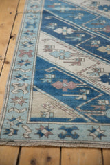 Distressed Oushak runner corner, showing starburst border, alternating blue and ivory diagonal stripes.