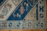 Distressed Oushak rug border with powder blue starburst pinwheels, indigo and ivory patterns, intact selvage.
