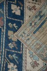 Folded distressed Oushak runner showing alternating indigo and ivory diagonal stripe patterns.