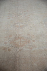 Distressed Oushak carpet with worn ivory pile and subtle tone-on-tone geometric patterns.