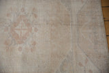Intact side cord selvage and worn texture of a distressed Oushak carpet.
