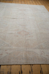 Vintage distressed Oushak rug, showing intact side selvage and mostly even worn pile.