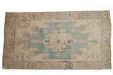 Vintage distressed Oushak rug with a geometric medallion on an abrashed powder blue and beige field.
