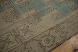 Hand-knotted geometric patterns on the evenly worn pile of a distressed Oushak rug.