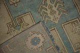 Corner detail showing the hand-knotted back and low pile of a distressed vintage Oushak rug.