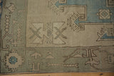 Visible knot heads and simplistic details on a powder blue and ivory distressed Oushak rug.