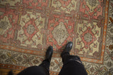 Vintage Distressed Oushak carpet featuring pale raspberry, beige geometric floral panels and border.