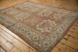 Distressed vintage Oushak rug with blush floral panels and tangerine starburst border.