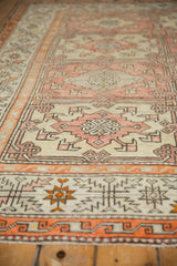 Worn tangerine border with serrated designs on distressed Turkish Oushak rug.