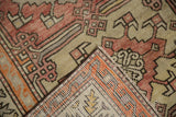 Close-up of vintage distressed Oushak rug corner, showing striped foundation and pale red motifs.