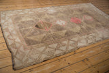 Distressed vintage Oushak rug corner with textured pile, wide beige and pink geometric border.
