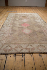 Vintage distressed Oushak carpet, displaying geometric paneled medallions and aged texture.