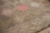 Distressed Oushak rug detail: worn pile, muted pink paneled patterns, tone-on-tone border.