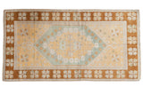 Vintage Distressed Oushak rug with saffron yellow field, powder blue medallion, and bronze floral border.