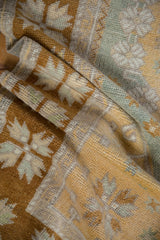 Soft, distressed pile of a vintage Oushak rug with quatrefoil floral design in saffron and blue.