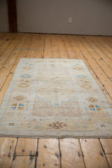 Distressed vintage Oushak runner with subtle ivory, pale saffron, and blue geometric motifs.