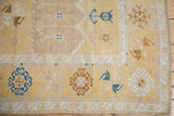 Distressed Oushak rug runner corner, with saffron, platinum, and sapphire border motifs.