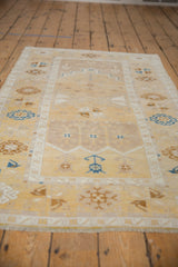 Distressed Oushak runner's geometric border in saffron, ivory, and sapphire blue.