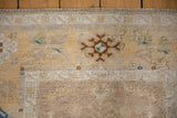 Distressed Oushak runner pile texture, ivory geometric border, and saffron yellow hues.