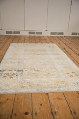Vintage distressed Oushak rug with an even worn texture and soft, faded tones.