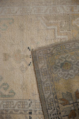 Faded, textured pile of a distressed vintage Oushak rug with visible wear and patterned reverse.
