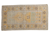 Pale saffron yellow distressed Oushak rug with plant motifs and wide geometric border, 3'4