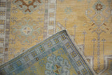 Folded corner detail showing distressed saffron yellow pile and geometric hand-knotted reverse.