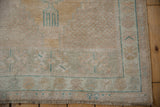 Distressed Oushak rug showing worn fringe, dusty teal lines, and saffron abrashed field.