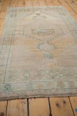 Vintage distressed Oushak rug pile, showing mostly even wear in muted saffron and dusty teal.