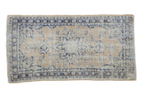 Distressed Oushak rug with pale saffron and denim blue starburst medallion pattern.
