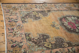 Distressed Oushak rug with mint green floral border, rococo outline, and dark beige field.