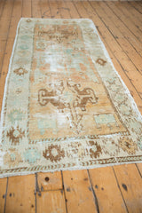 Distressed Oushak runner's main border showing serrated geometric motifs and worn pile.