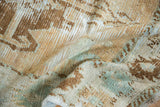 Worn, textural detail of the distressed Oushak rug in beige, copper, and seafoam.