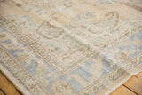 Distressed vintage Oushak carpet border with pale apricot, blue, beige tones, and visible knot heads.