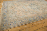 Distressed Oushak rug corner with pale blue, apricot geometric border, even wear, foundation showing.