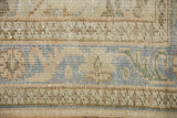 Distressed Oushak rug pile with visible knot heads, pale blue and beige patterns.