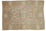 Distressed vintage Oushak rug with geometric medallion, soft gold, rose, and mint tones.