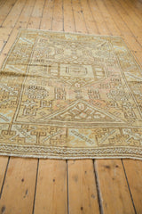 Distressed Oushak rug's geometric border with hook and latch motifs and soft gold fringe.