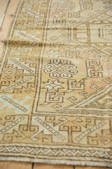 Distressed Oushak rug detail with geometric motifs, knot head wear, and faint foundation.