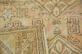 Distressed Oushak rug pile with pale rose and ivory geometric motifs and selvage.