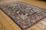 Distressed Oushak rug close-up: worn navy field, red Ardebil medallion, faint foundation.