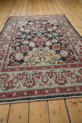 Distressed Oushak rug's lower corner, featuring worn pile, cherry red and dusty gold cloudband border.
