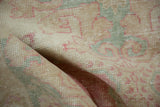 Distressed hand knotted Oushak rug pile in rose, seafoam, beige, and sand tones.
