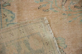 Distressed vintage Oushak carpet's worn pile, exposed knot heads, and woven reverse.