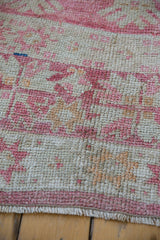 Distressed Turkish Oushak rug pile with raspberry, saffron, ivory geometric plant patterns and fringe.