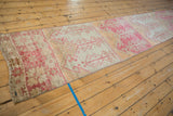 Distressed Oushak runner end, raspberry red geometric plants, ivory ground, intact selvage.