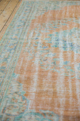 Distressed pile texture of vintage Oushak rug, showing tangerine orange and seafoam green.