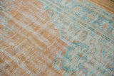 Softened texture of a distressed Oushak rug, with pale tangerine and seafoam patterns.